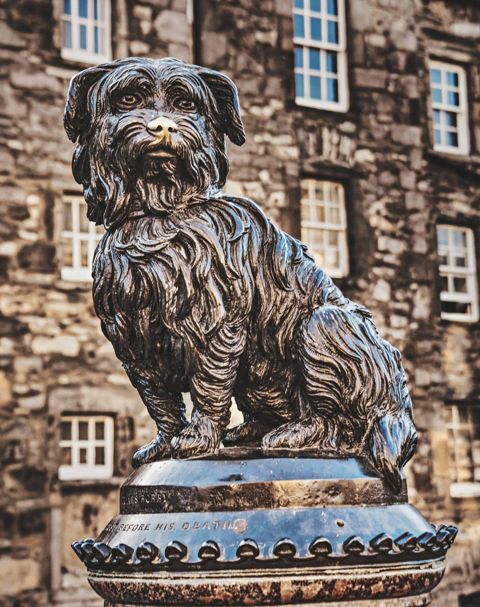 a statue of a dog sitting on top of a fire hydrant